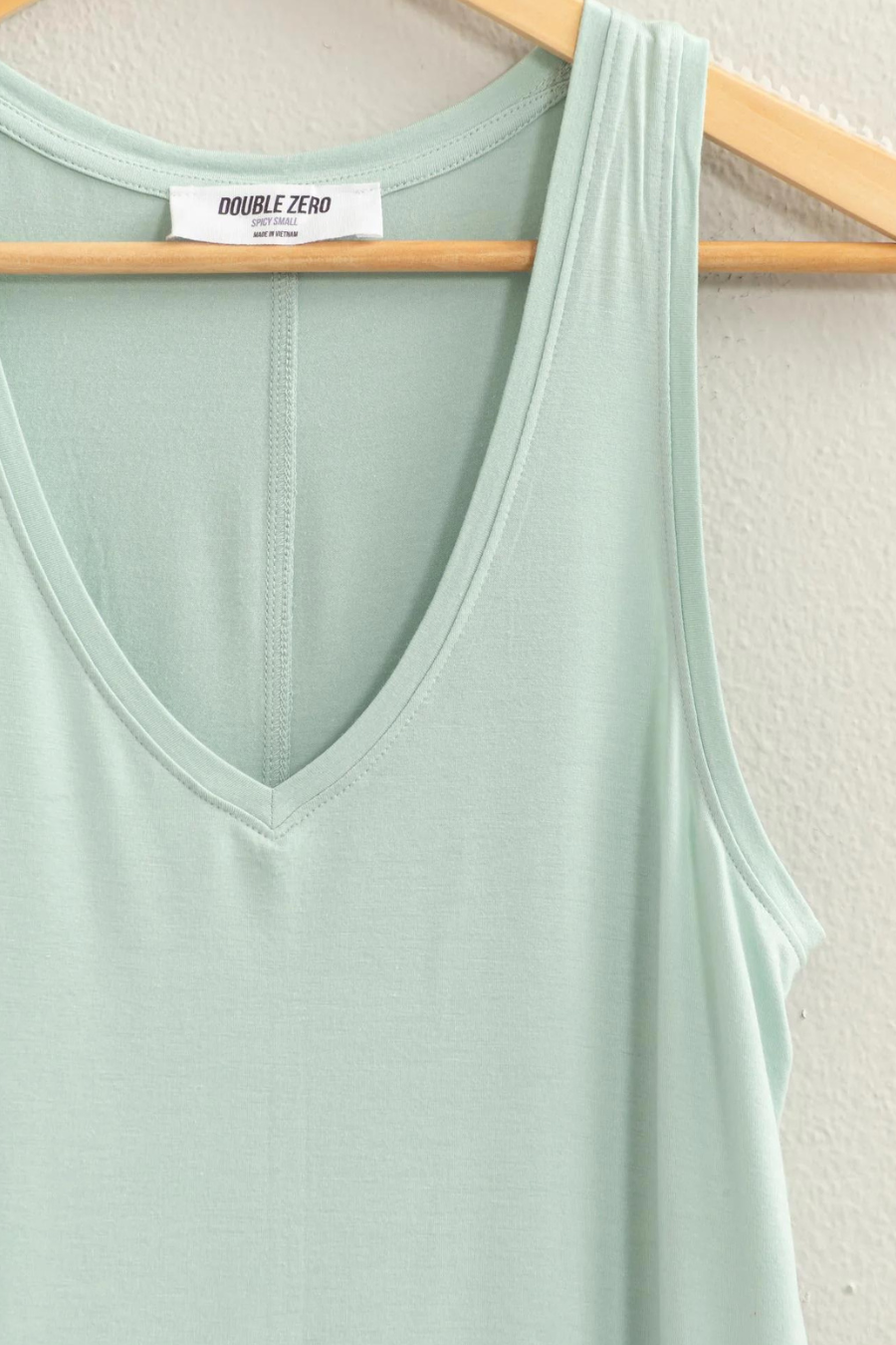 close up detail shot of joey v neck tank in the color seafoam hanging on a hanger