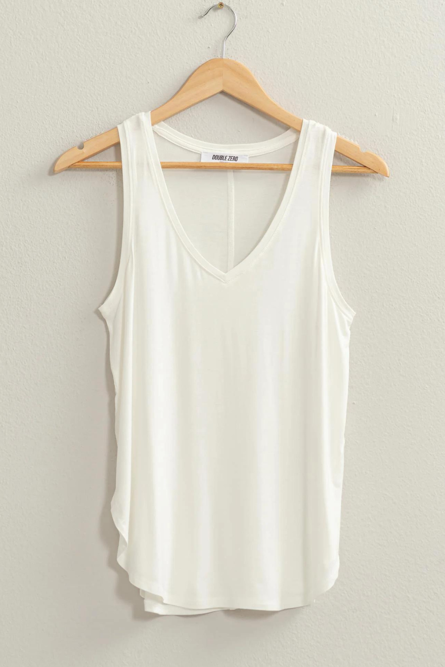 front view of joey v neck tank in the color ivory hanging on a hanger 
