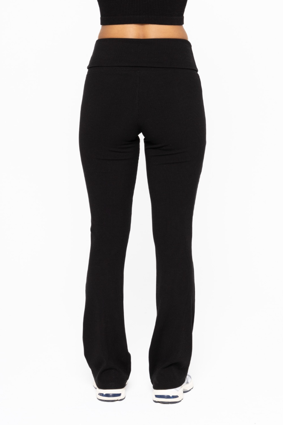 back view of the folded over waist flare pants in the color black 