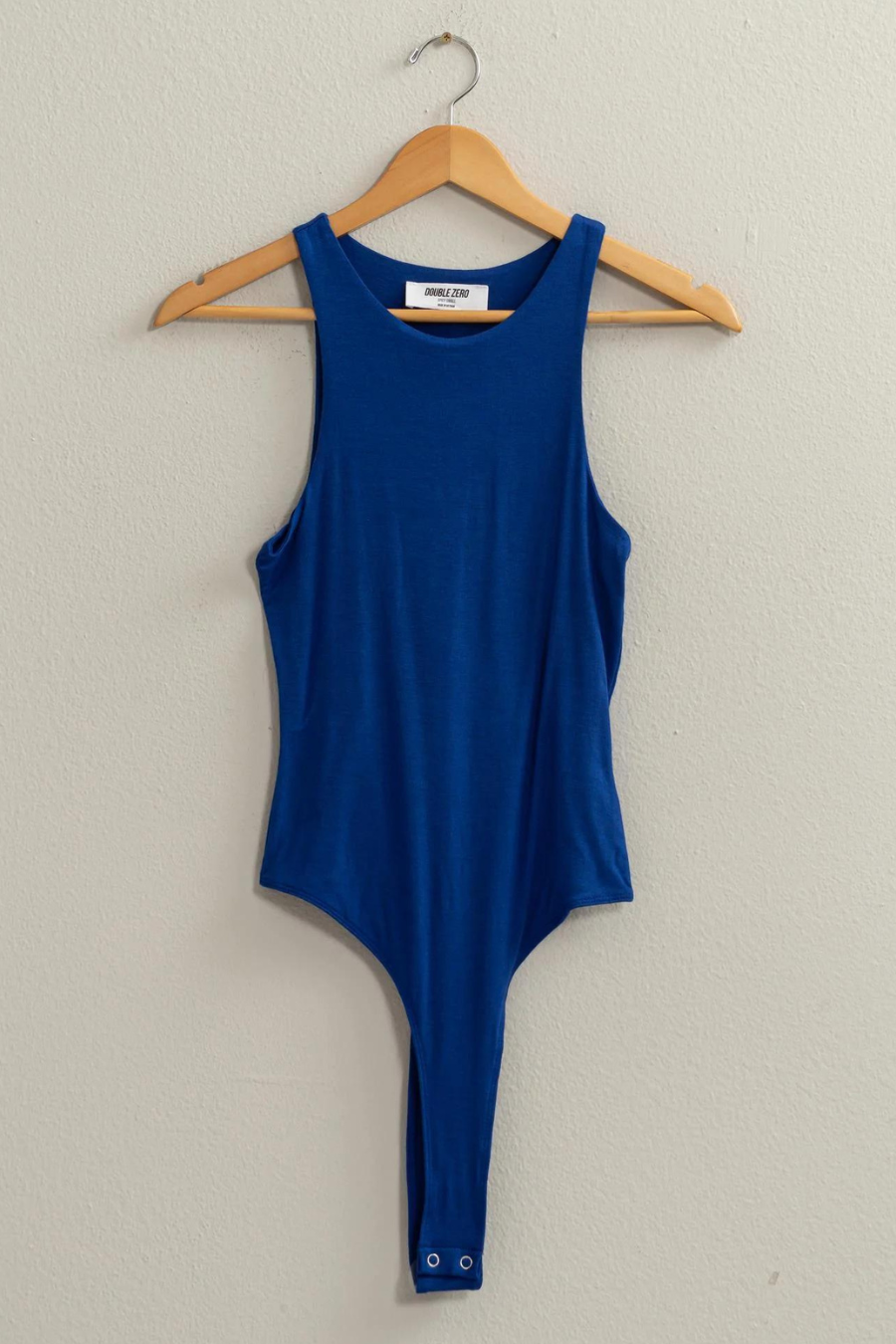 fulll length front view of sad tank bodysuit in the color blue, hanging on wooden hanger 
