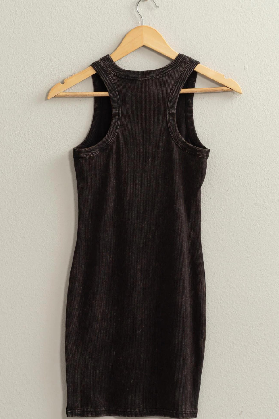 close up back view of lex acid wash ribbed dress in the color black, hanging on a hanger 