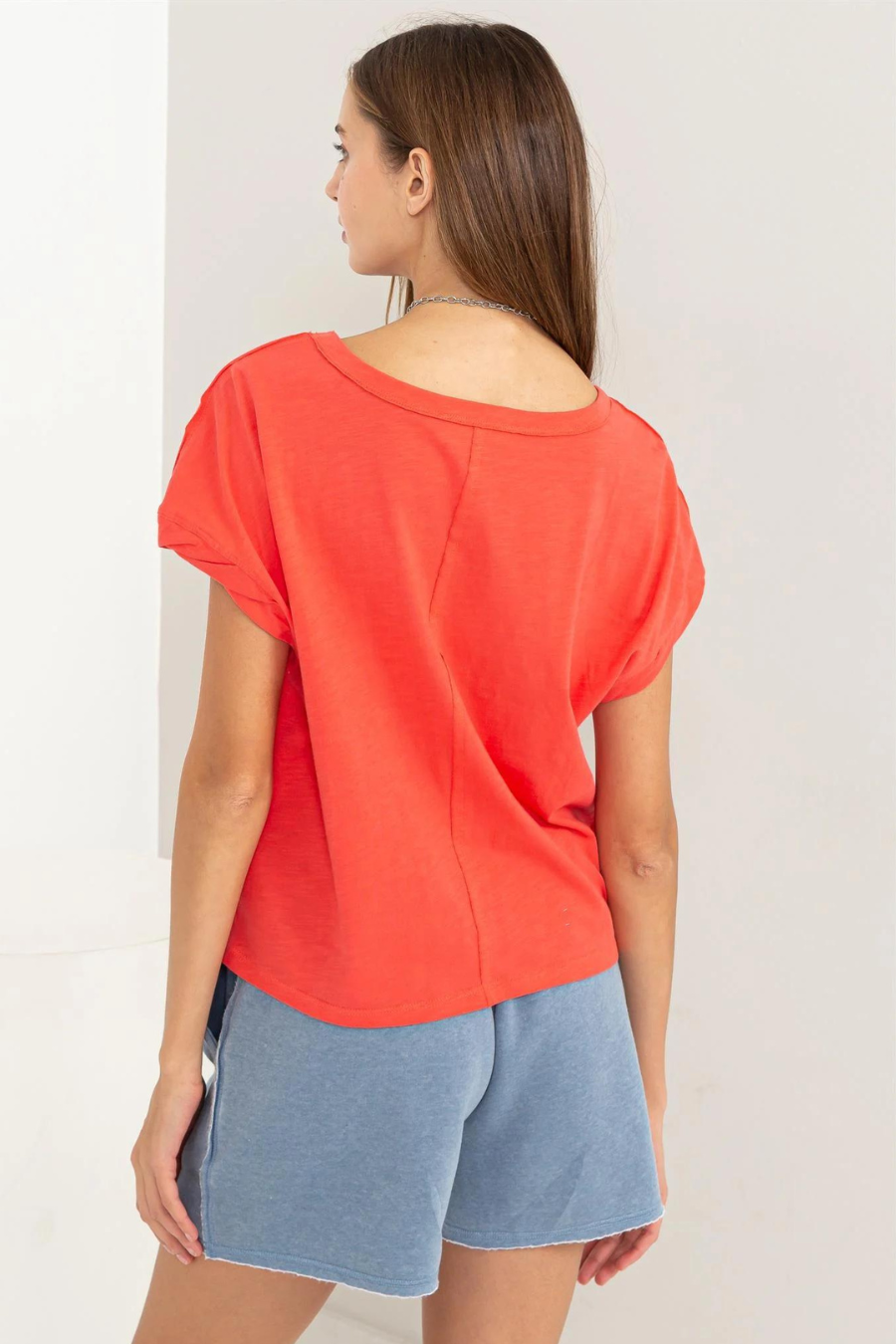 close up back view of hunter raw edge tee in the color coral 