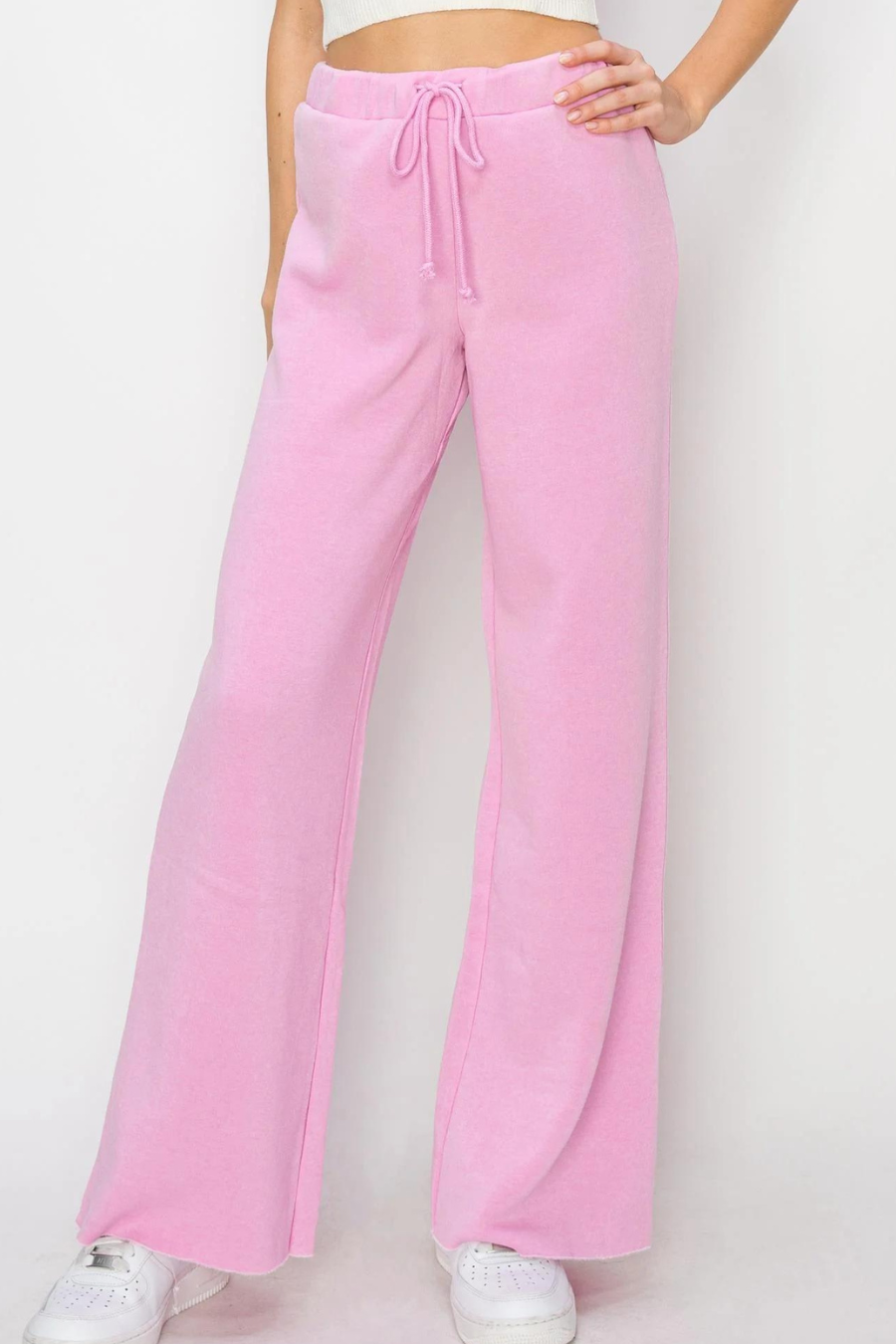 close up of girl wearing pink eve drawstring pants with white tennis shoes 