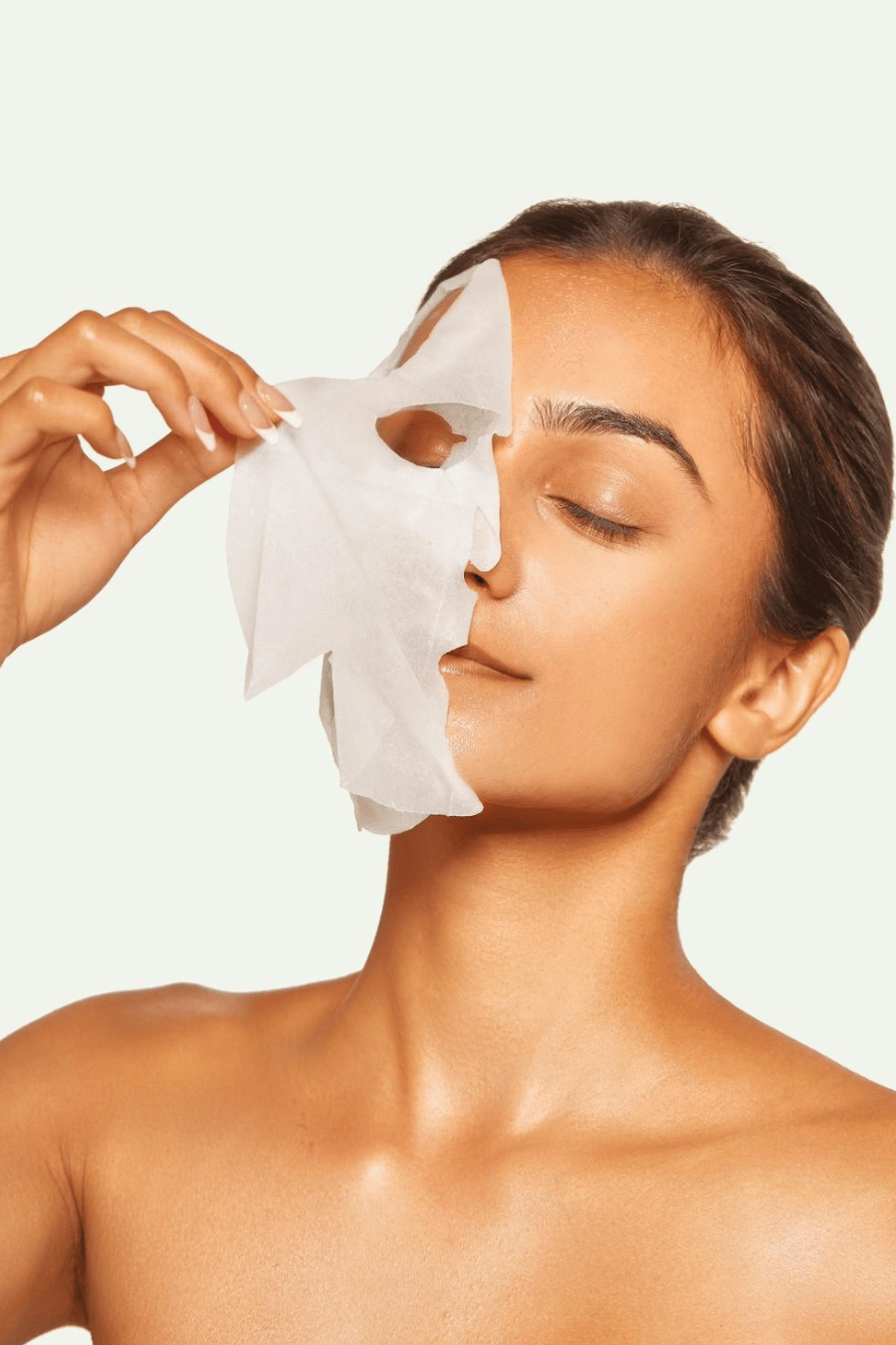 girl peeling sheet mask off face