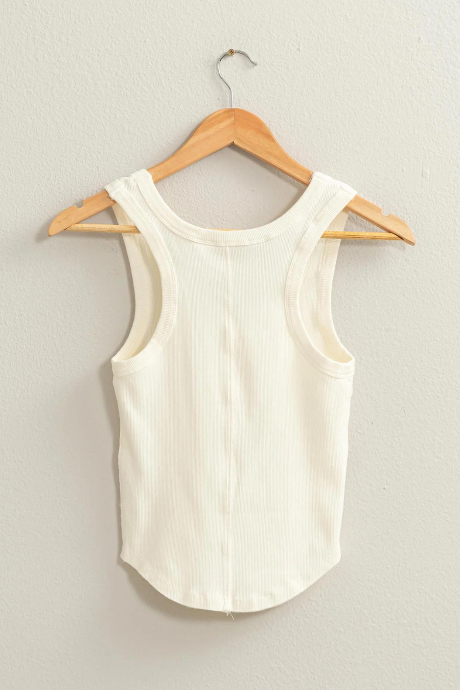 back shot of dixie acid wash tank top in ivory hanging one a wooden hanger 