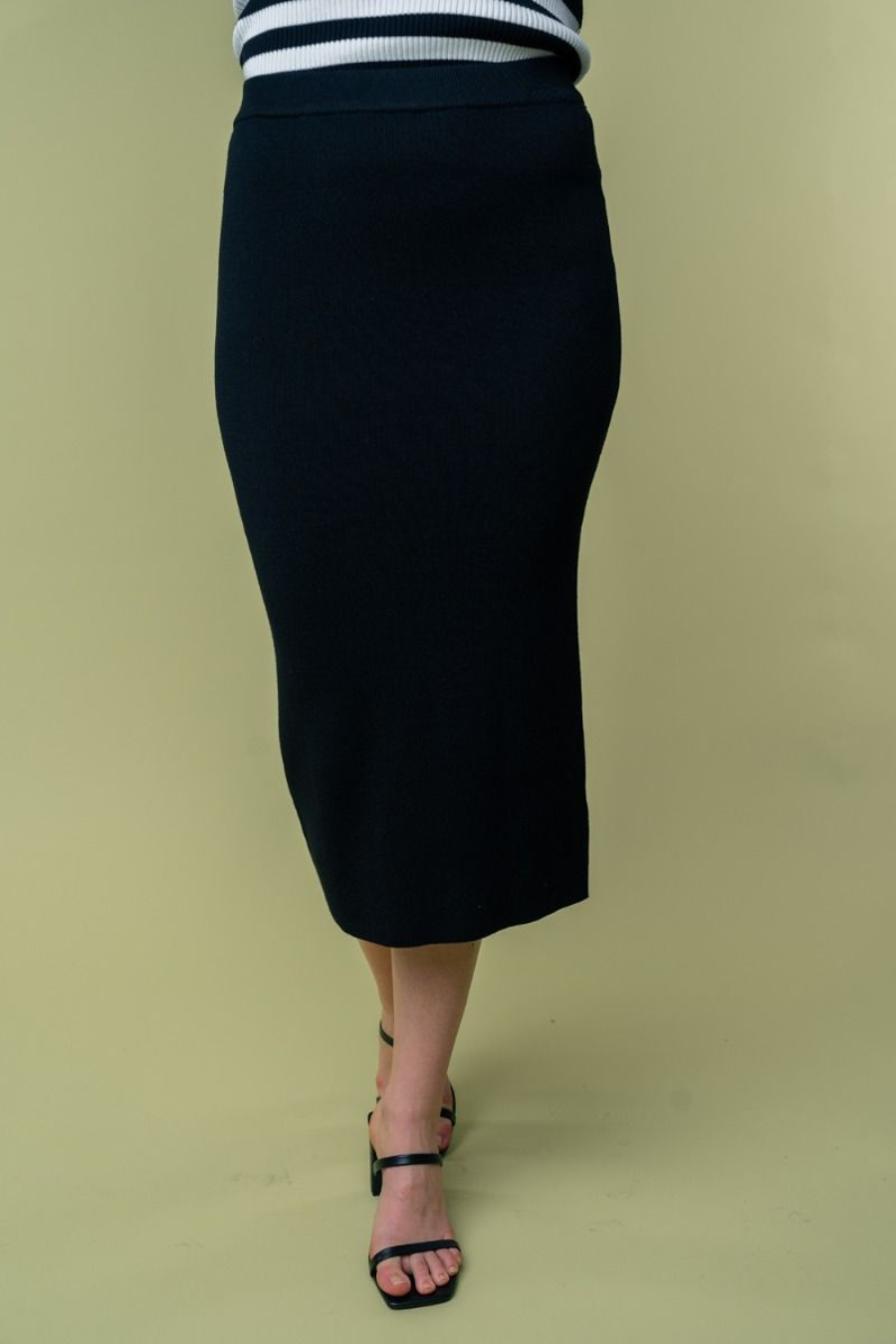 close up front view of Juliana high waisted knit midi skirt in the color black . model is wearing it with heels
