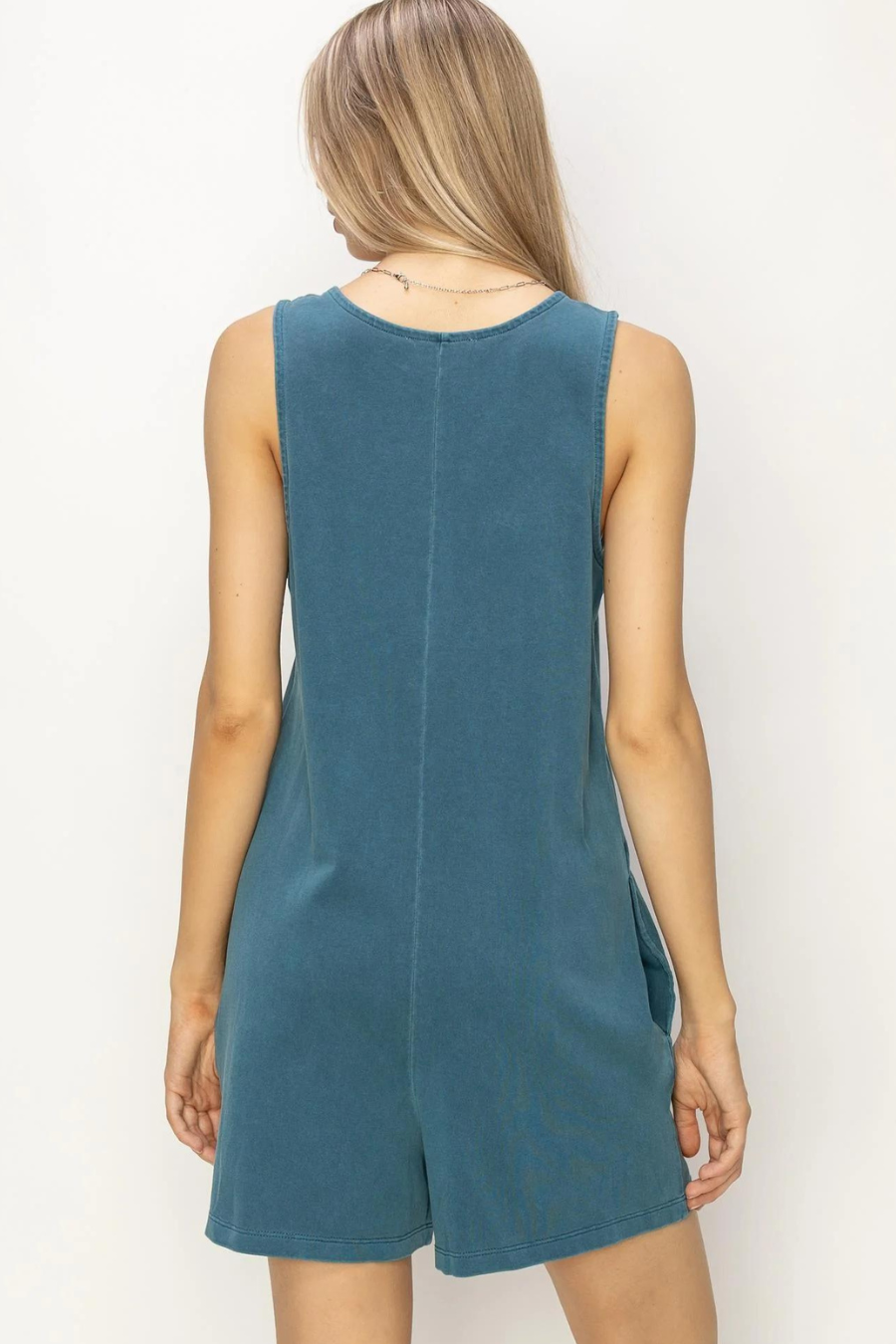 showing back view of girl in teal romper 