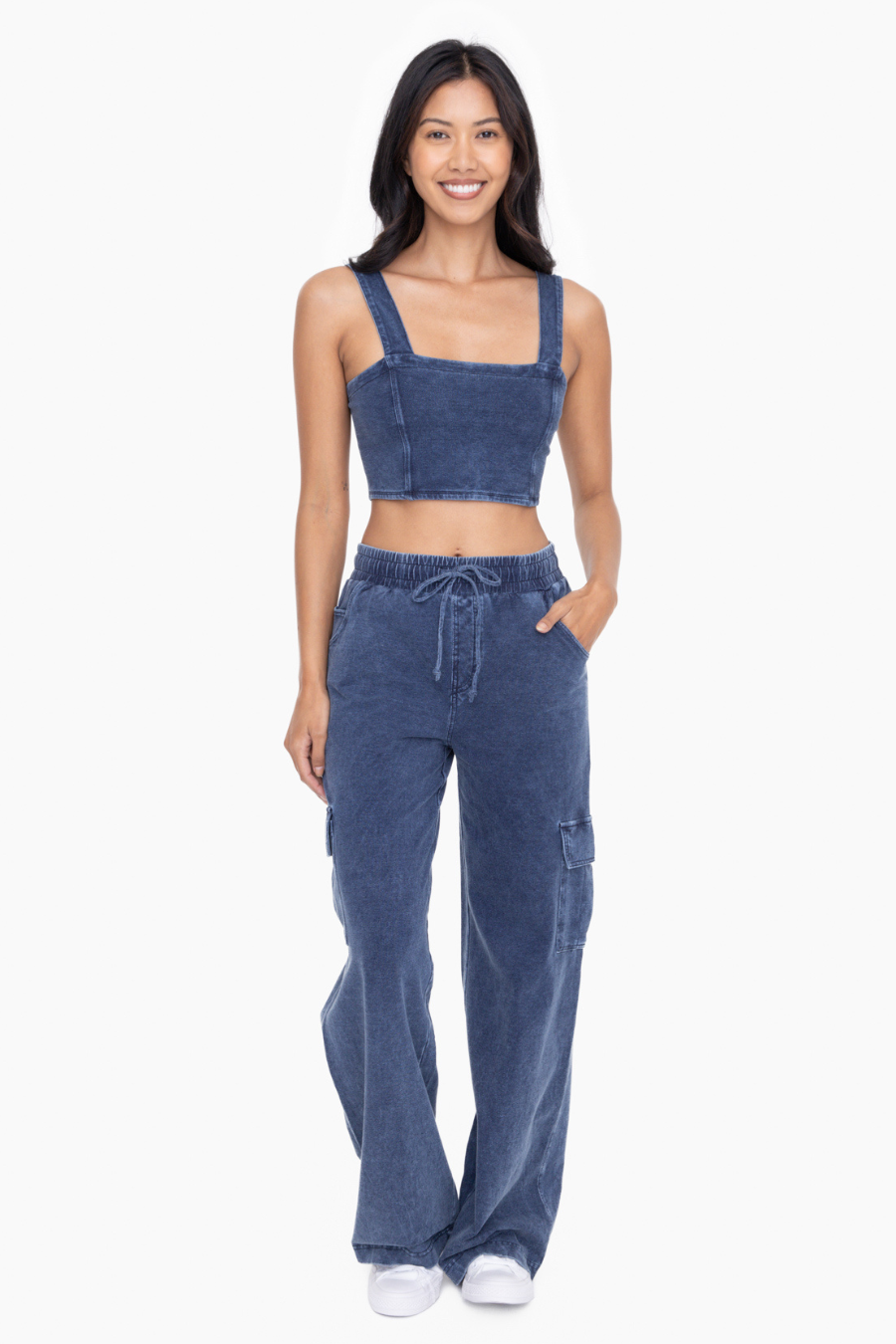 front full length view of cropped denim bra top. model is wearing it with matching denim pants sold separately