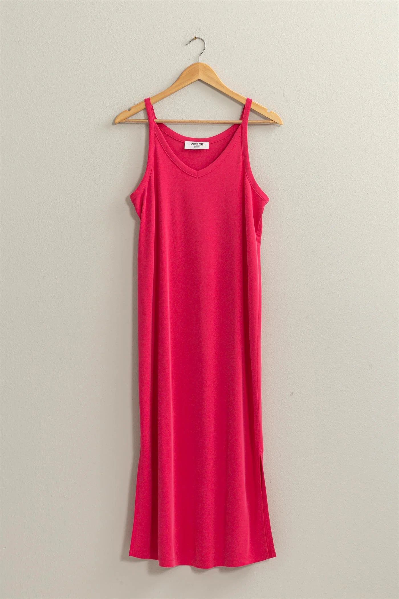 full length front view of birdie v neck midi dress in the color pink hanging on a wooden hanger 
