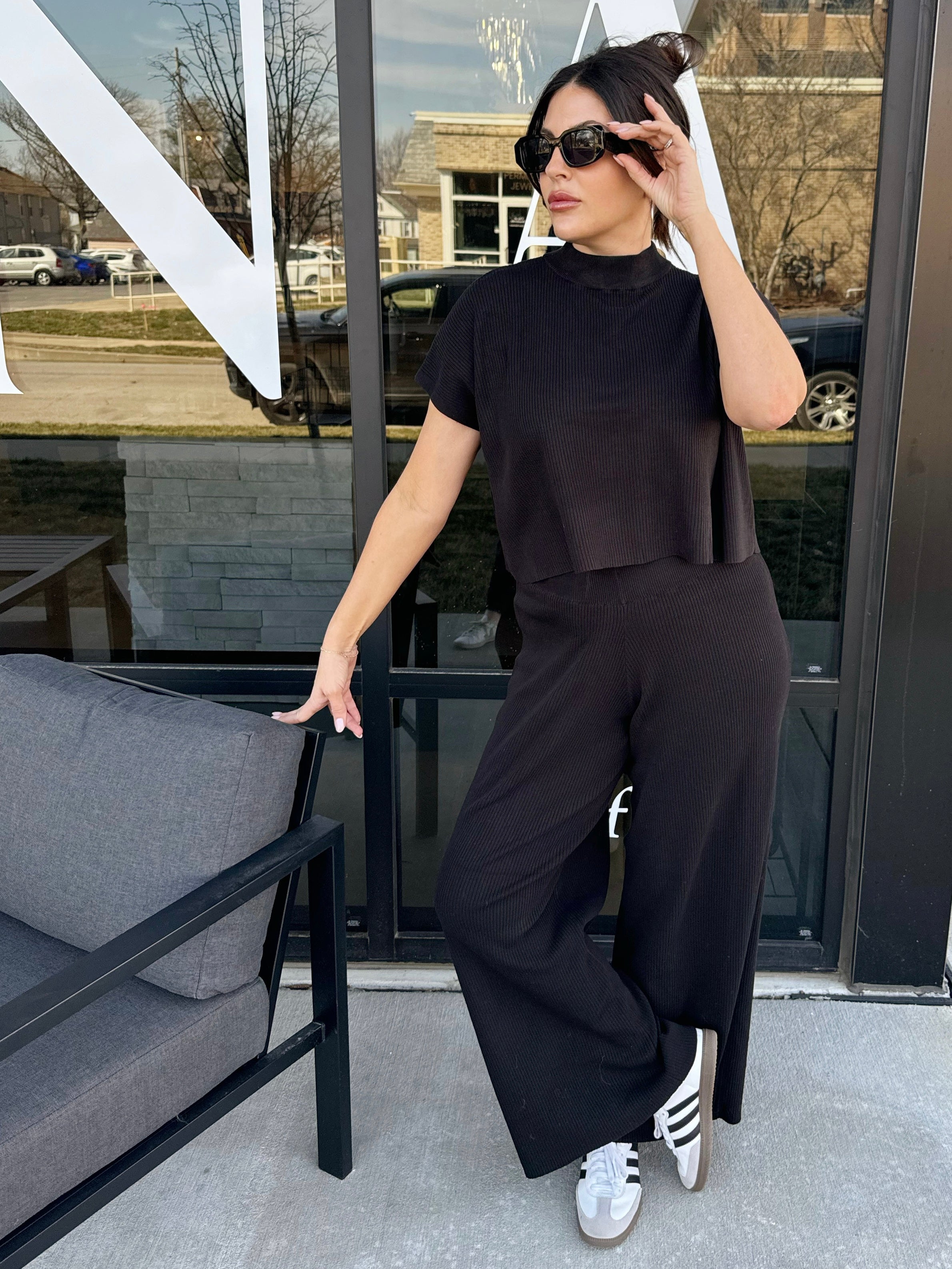 girl wearing sunglasses wearing black knit top and wide leg pants set 