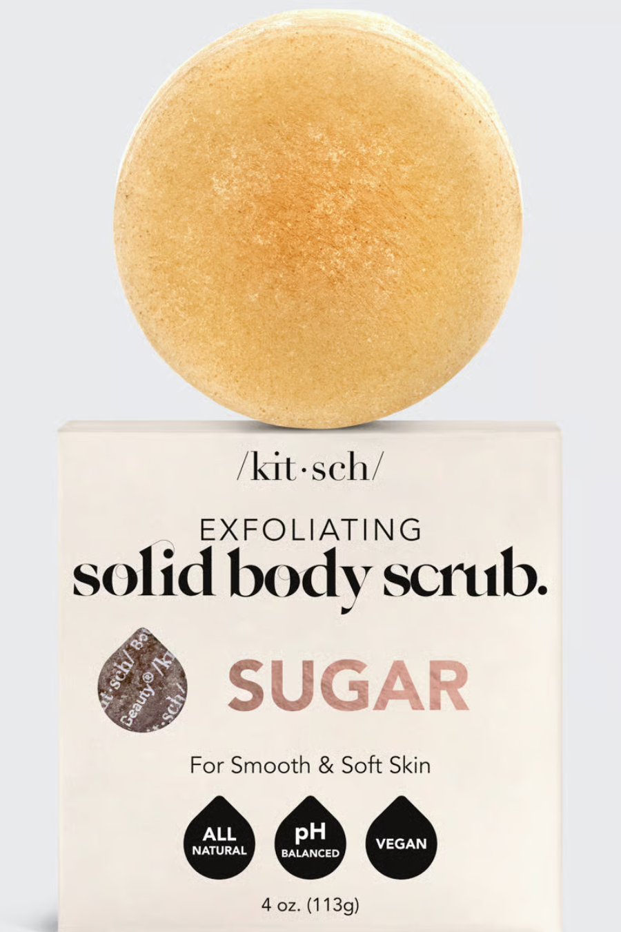 sugar scrub bar sitting on top of its packaging 