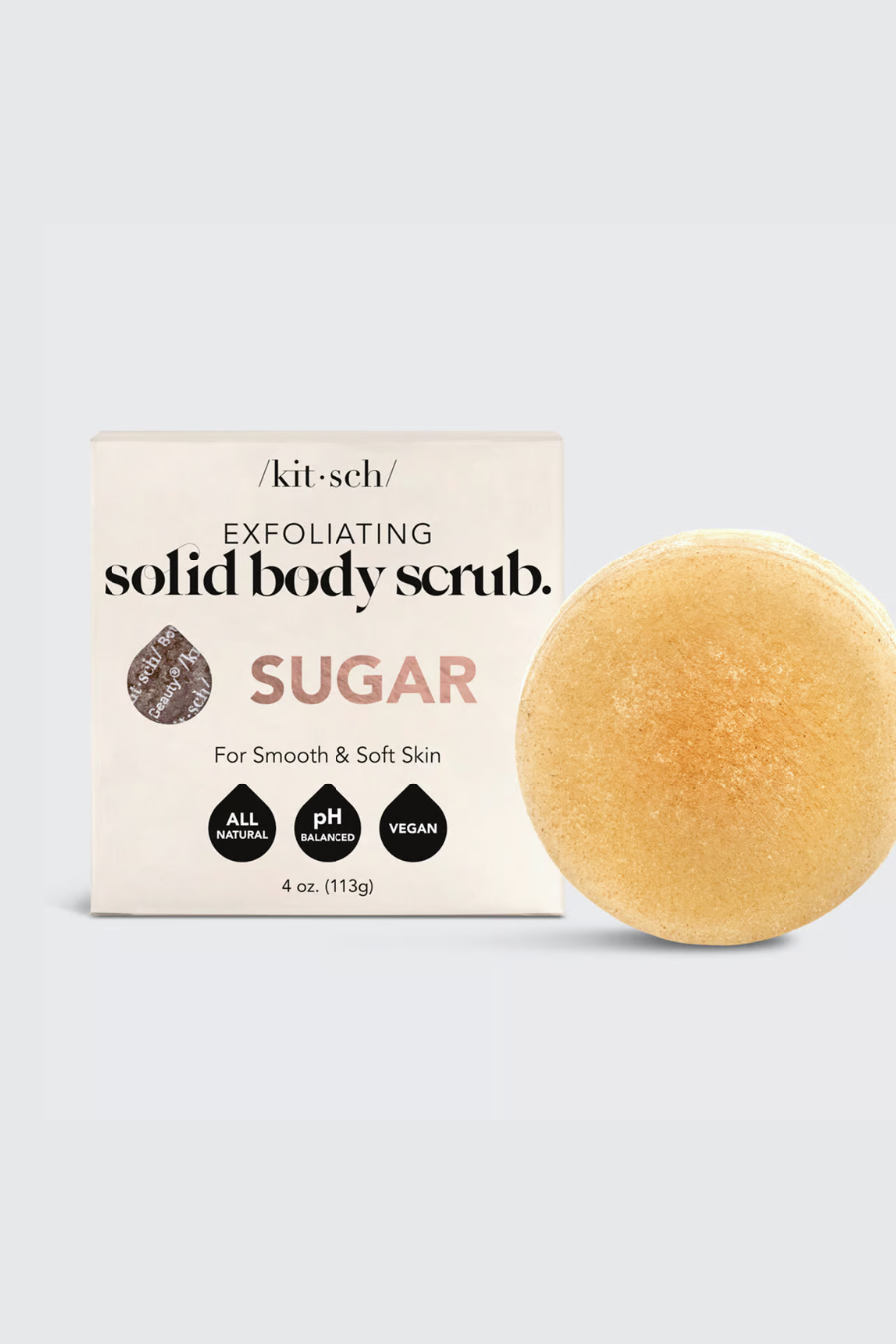 sugar scrub bar sitting next to its packaging 