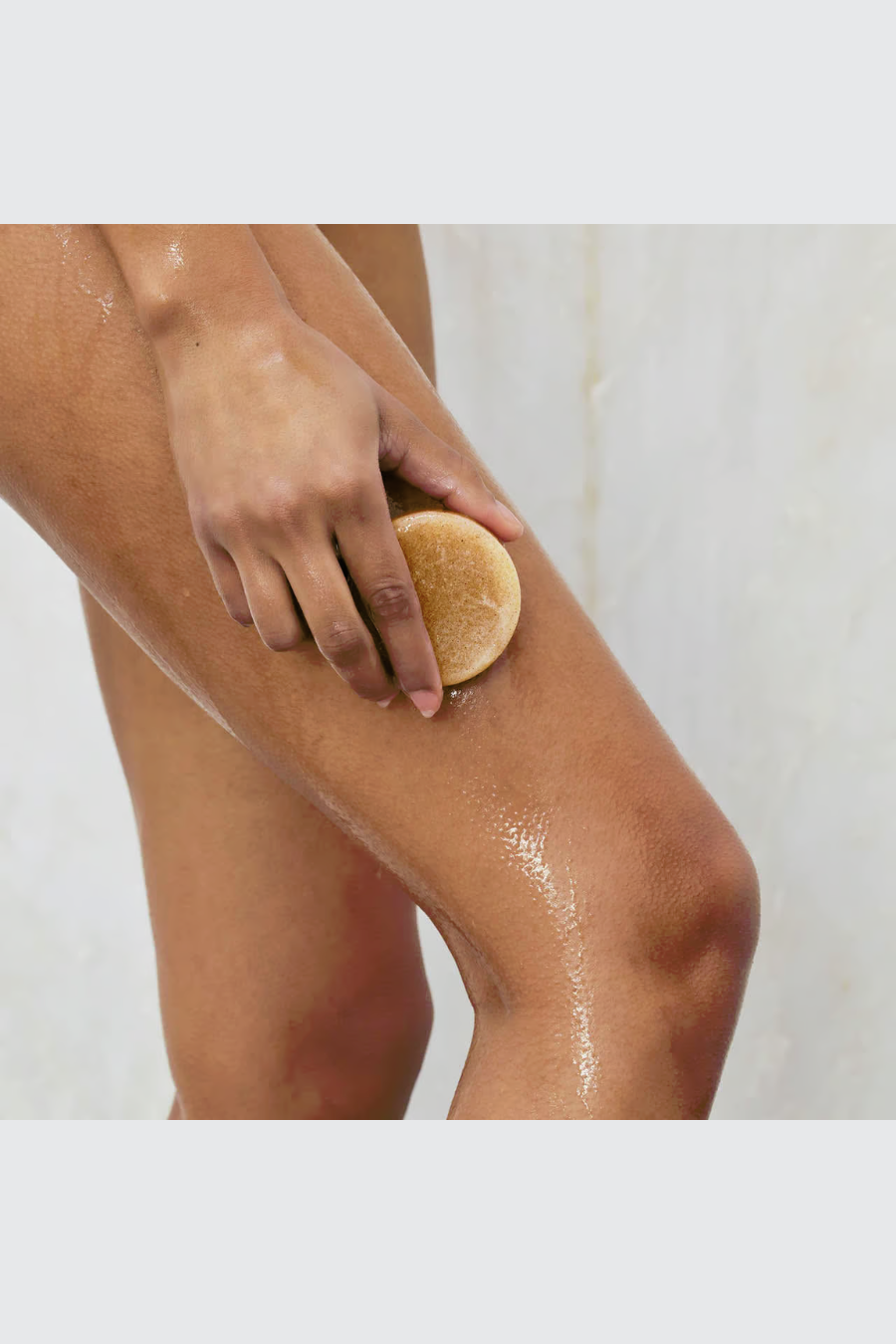 girl using sugar scrub bar in shower 