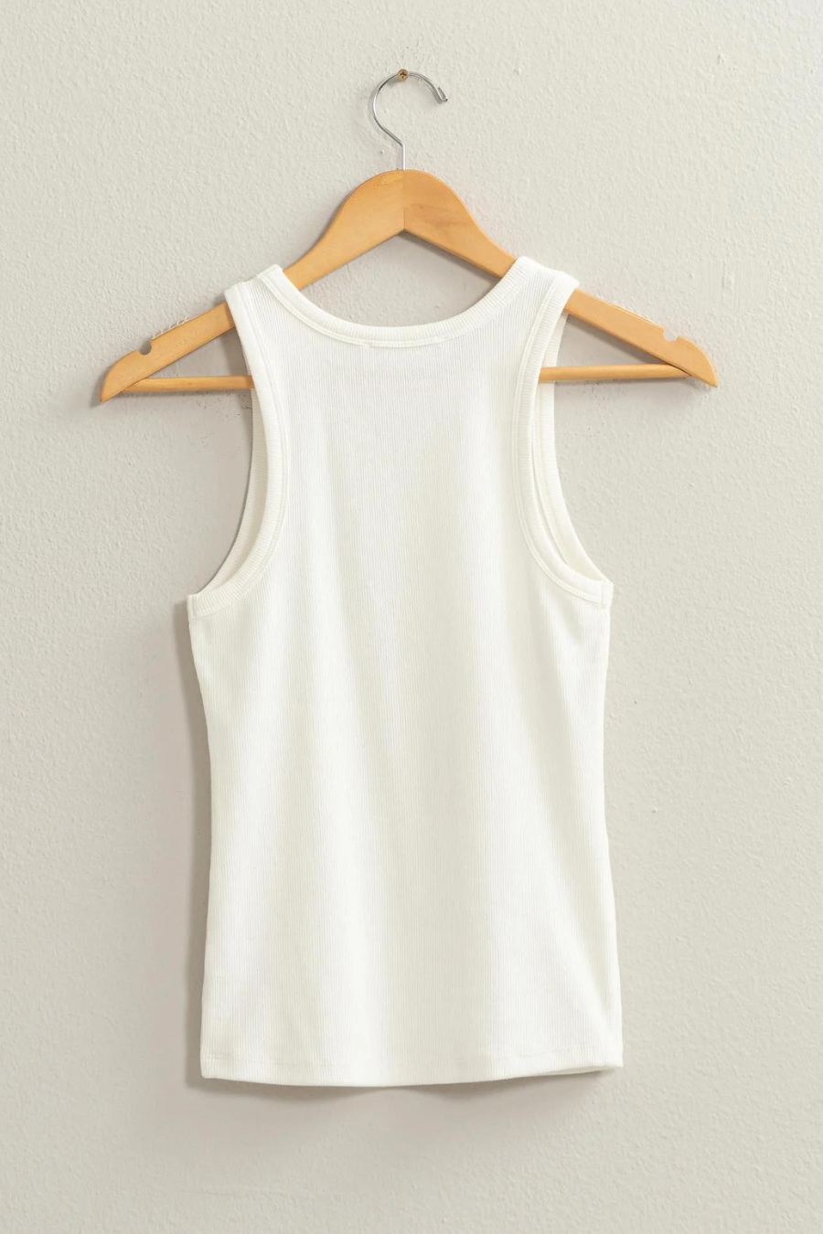 back view of white tank top on wooden hanger 