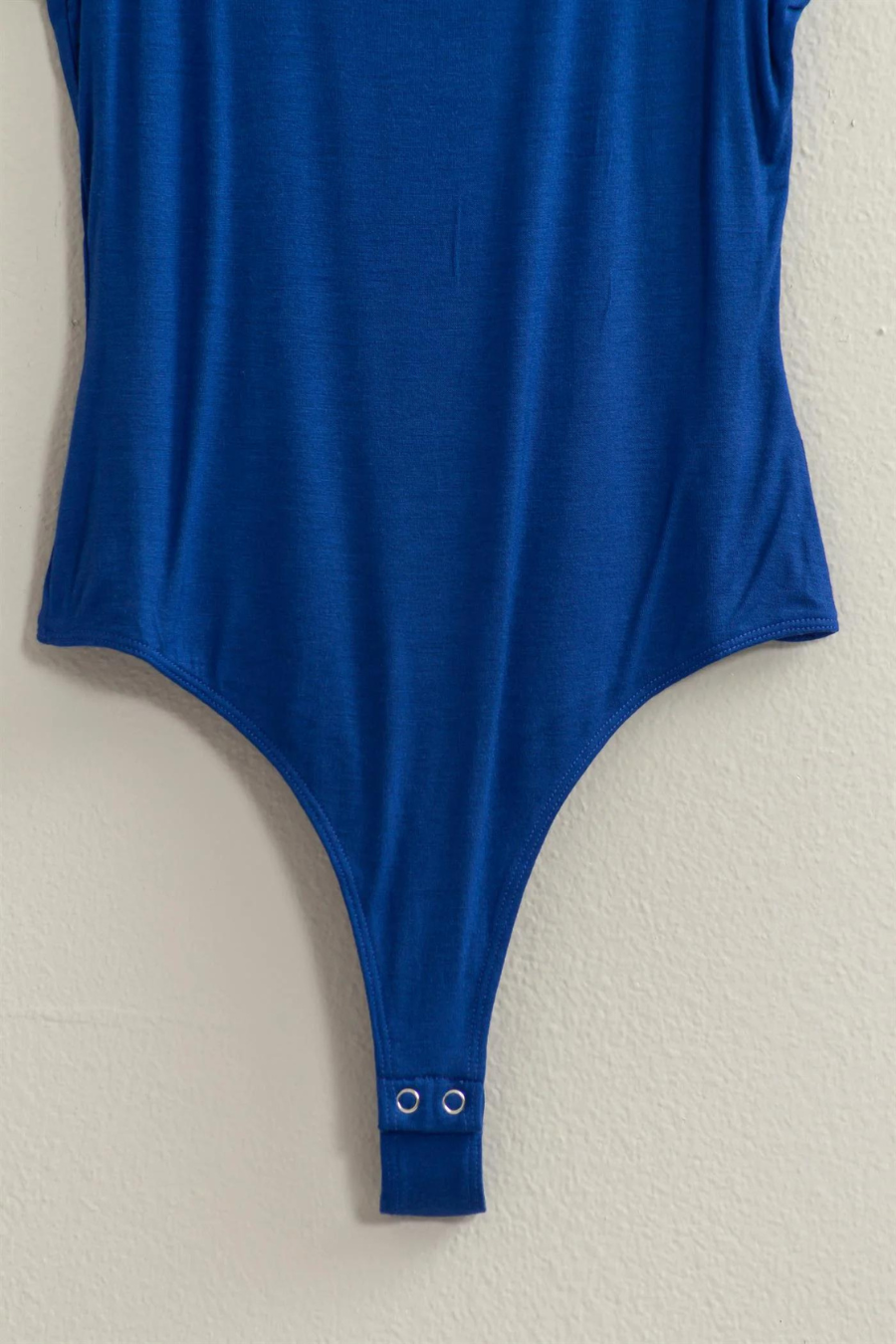 close up of snap closure for the Brinkley body suit, shown in the color blue