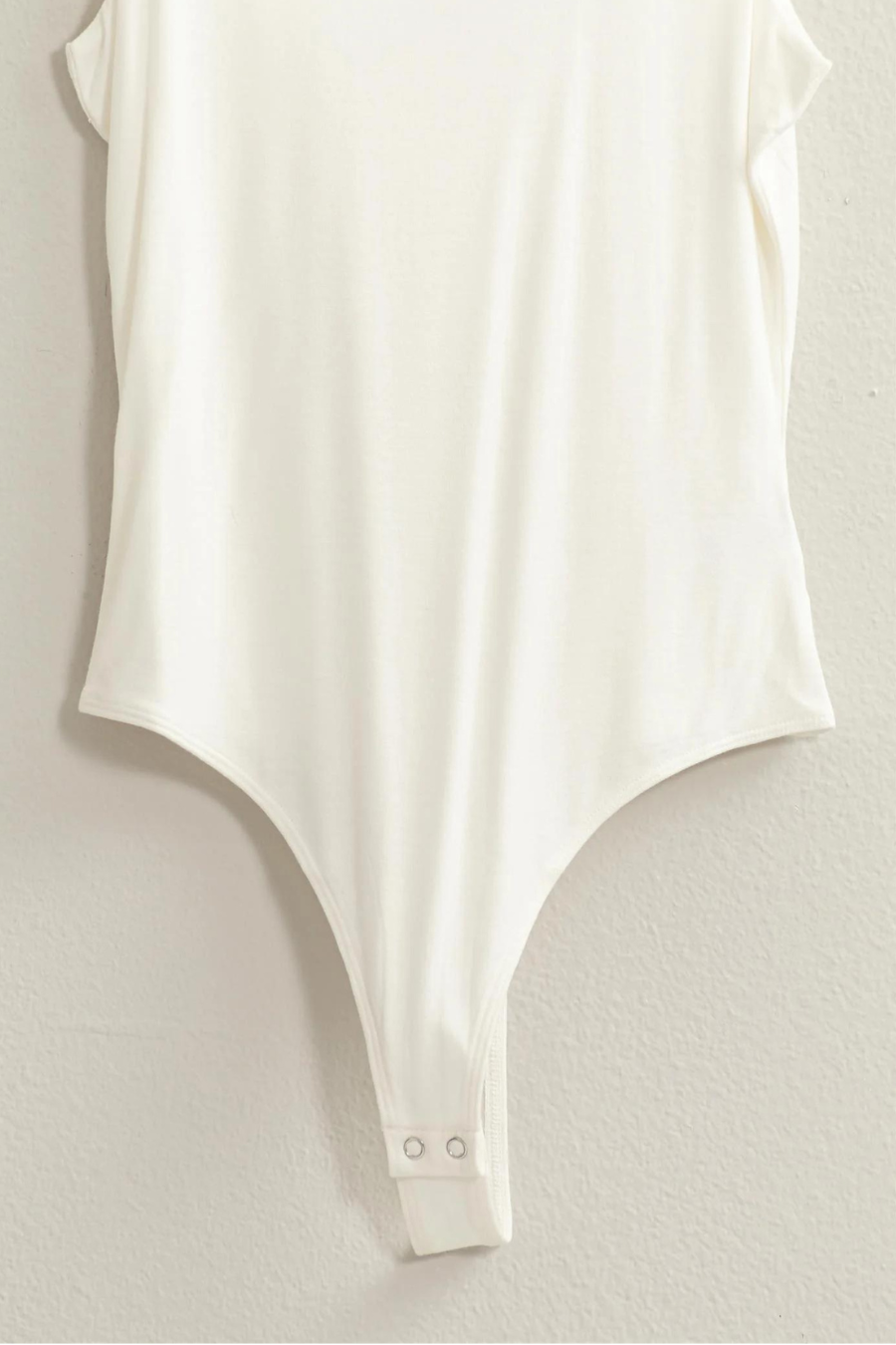 close up of snap closure for the brinkley bodysuit, shown in the color ivory 