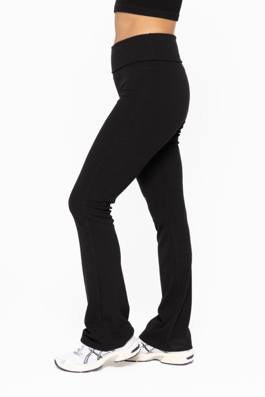 side view of the folded over waist flare pants in the color black 