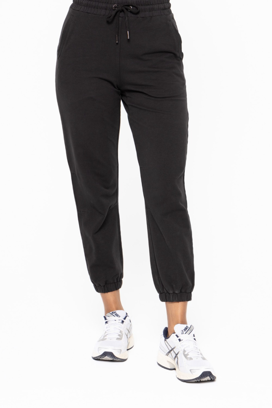 front close up view of the swoop back twill joggers in the color black. model is wearing them with white tennis shoes 