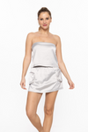 front view of smooth stride loose tube top in silver. model is wearing it with matching skort 