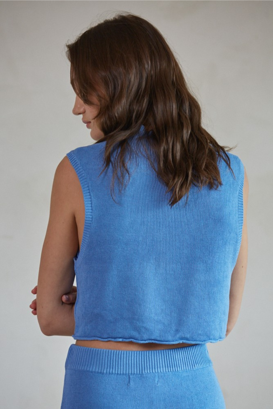 close up back view of the celeste knit sweater mock neck crop top in the color blue 
