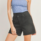 close up of girl wearing blue flower top and black criss cross denim shorts 