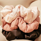 3 satin scrunchies stacked on top of each other, blush, rosewood, and brown
