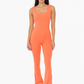 front full length view of the Venice twist back flare jumpsuit  in the color coral