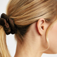 girl with blonde hair pulled into a ponytail with a brown satin Scrunchie 
