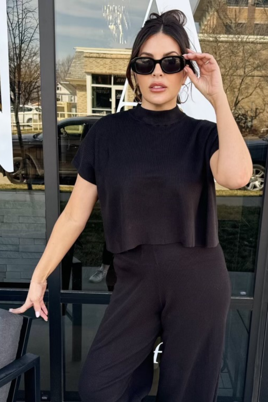girl wearing sunglasses and the ribbed knit sweater top with matching pants.