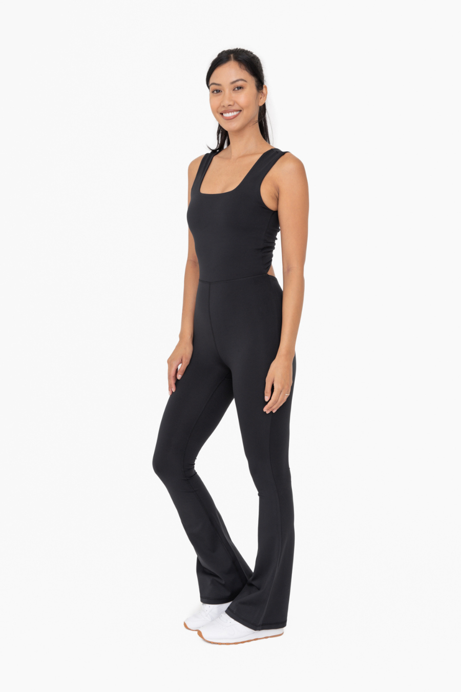 side view of the Venice twist back flare jumpsuit in the color black