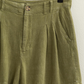 close up of olive shorts on wooden hanger 