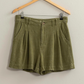 full length shot of olive linen shorts on a wooden hanger 