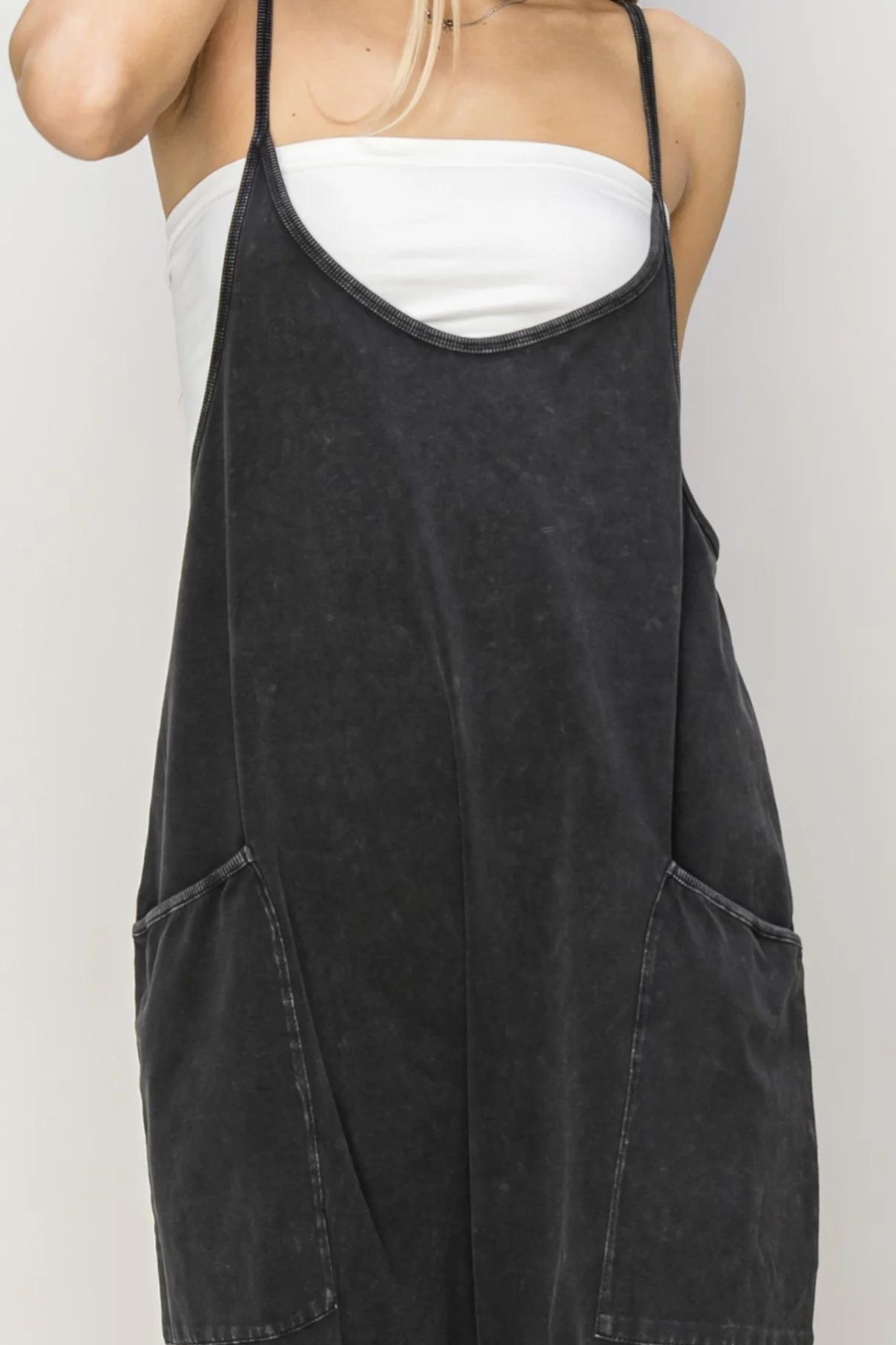 close up front shot of franny romper in black, girl is wearing a white cami underneath it 