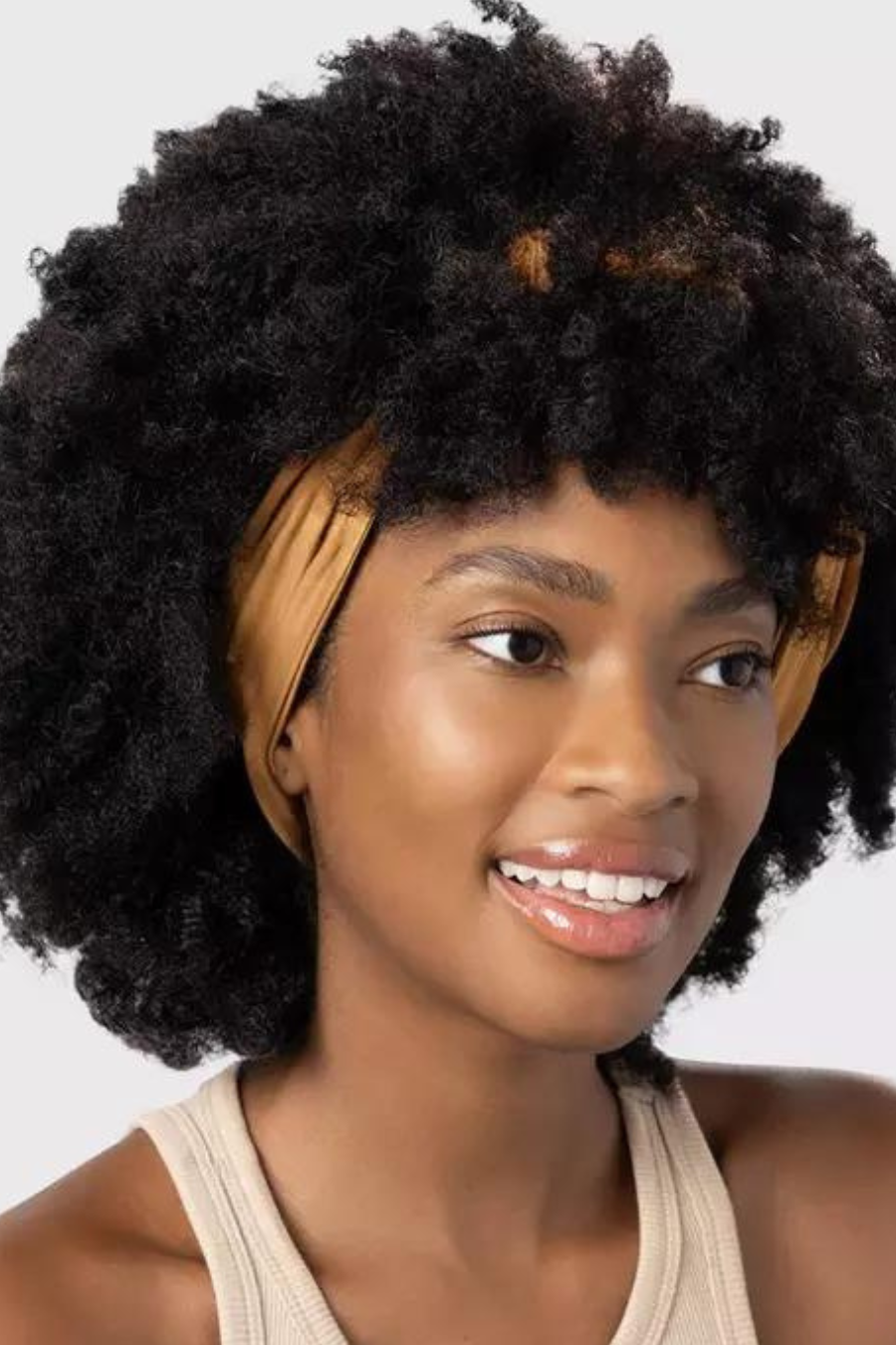 girl with curly hair wearing her hair pulled back by wide fabric headband