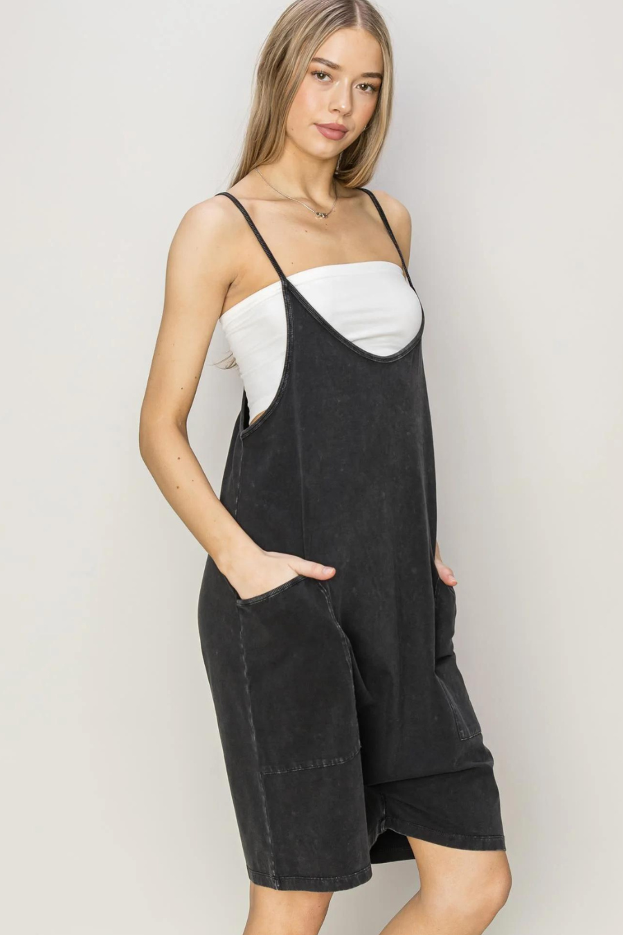 side view of girl wearing franny mineral romper In black 