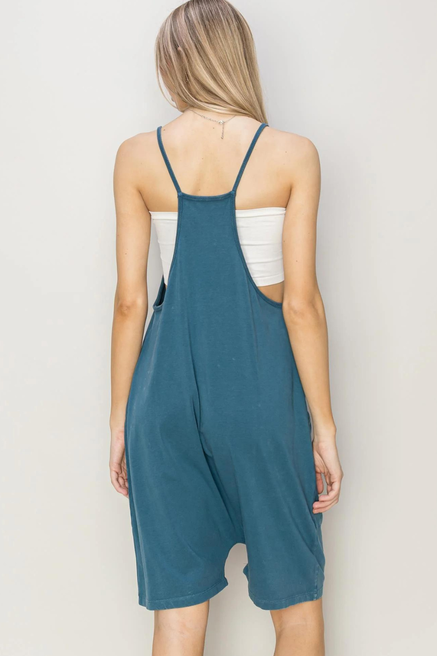 back view of the franny mineral washed romper in teal with a white cami under it 