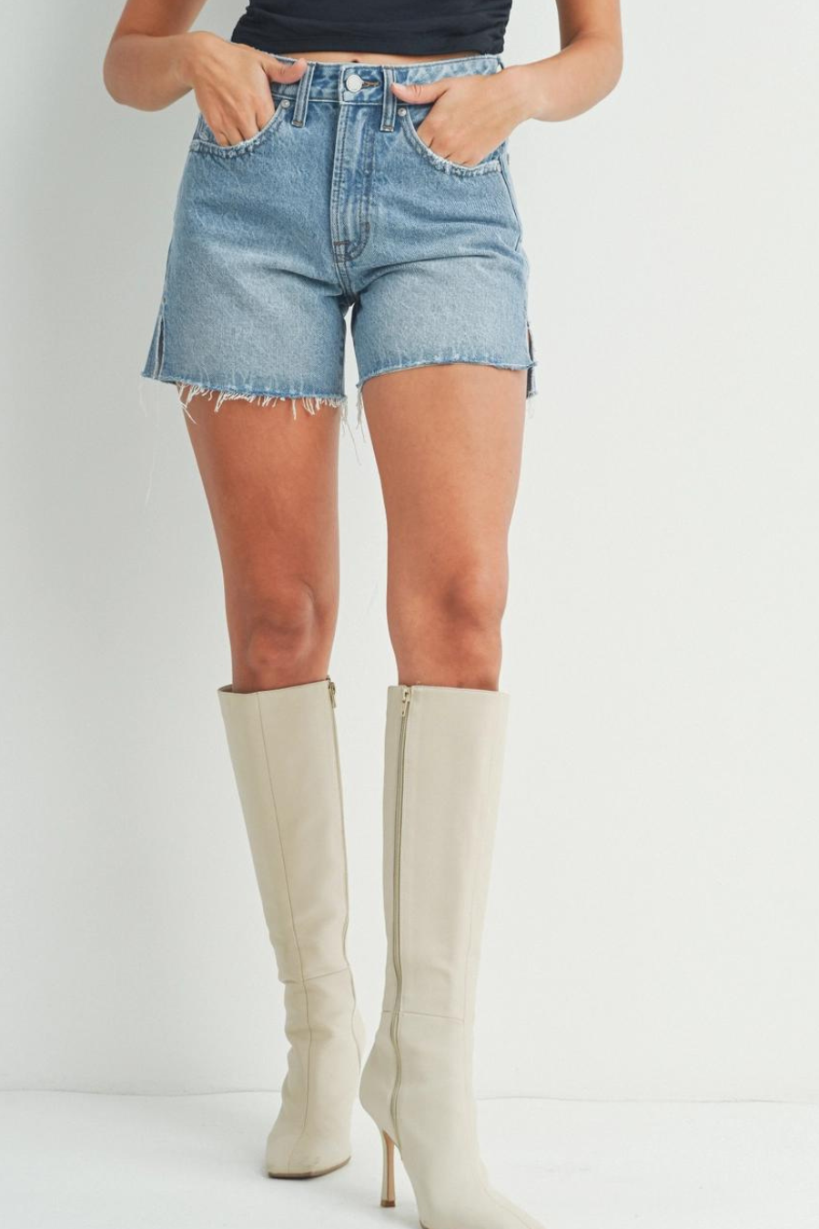 close of girl wearing denim shorts with slits on the side paired with white boots 