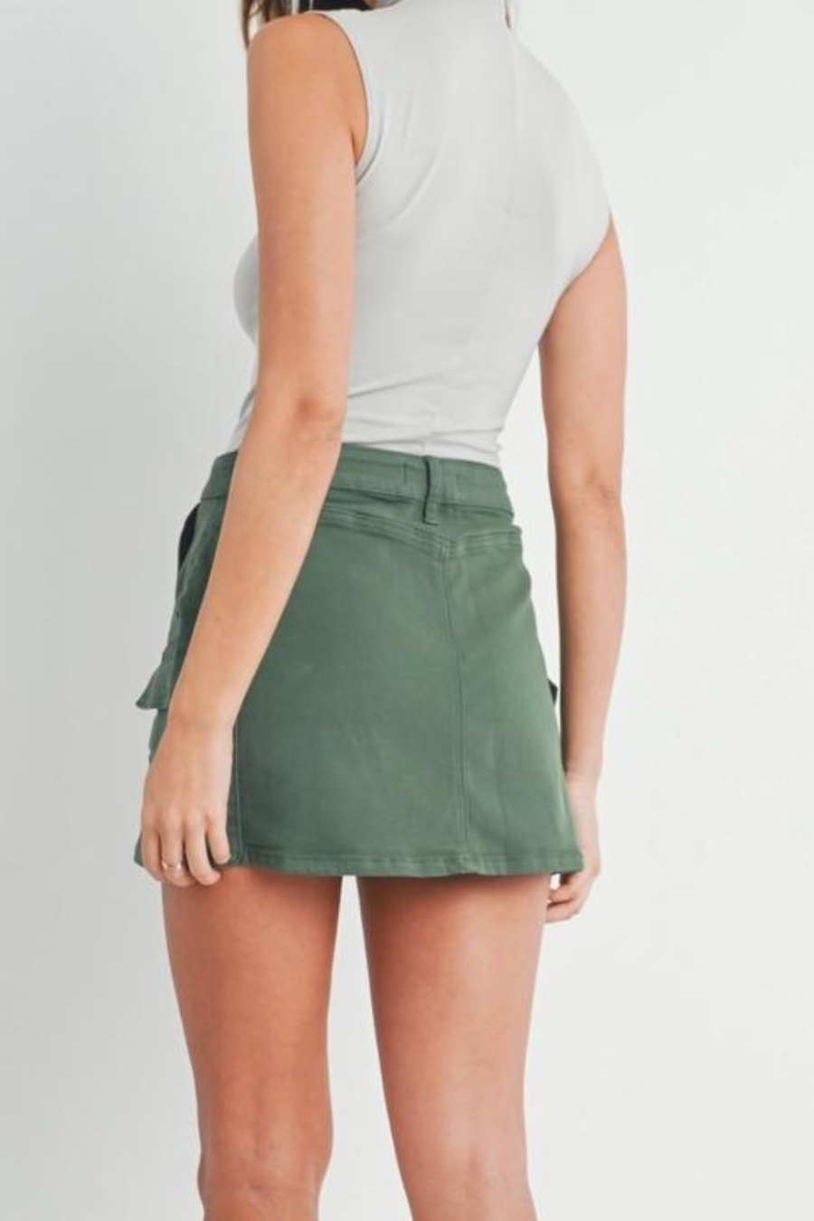 close up shot of the back of girl wearing gray turtleneck tank top and olive green cargo skirt 