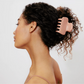 girl with curly hair pulled into updo with blush claw clip