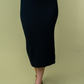 close up front  view of Juliana high waisted knit midi skirt in the color black . model is wearing it with heels 