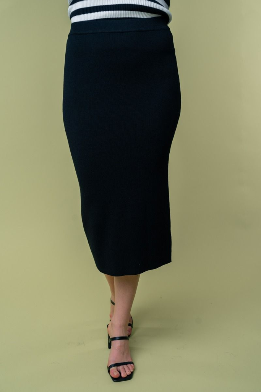 close up front  view of Juliana high waisted knit midi skirt in the color black . model is wearing it with heels 