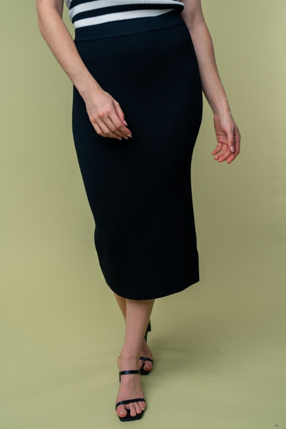 close up front  view of Juliana high waisted knit midi skirt in the color black . model is wearing it with heels 