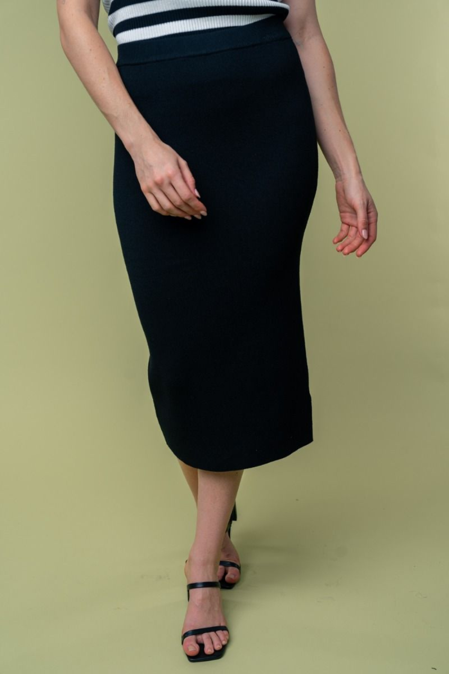 close up front  view of Juliana high waisted knit midi skirt in the color black . model is wearing it with heels 