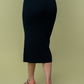 close up back view of Juliana high waisted knit midi skirt in the color black . model is wearing it with heels 