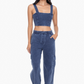 front full length view of cropped denim bra top. model is wearing it with matching denim pants sold separately 