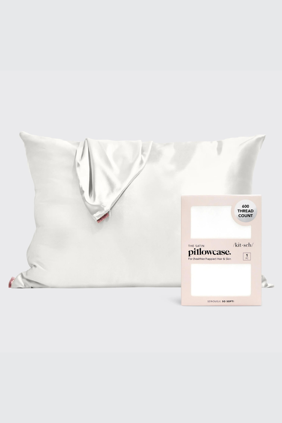 pillow sitting upright with satin pillowcase drapped over it and a satin pillowcase in its packaging in front of it 